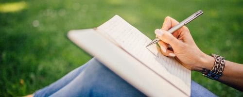 person writing in a notebook