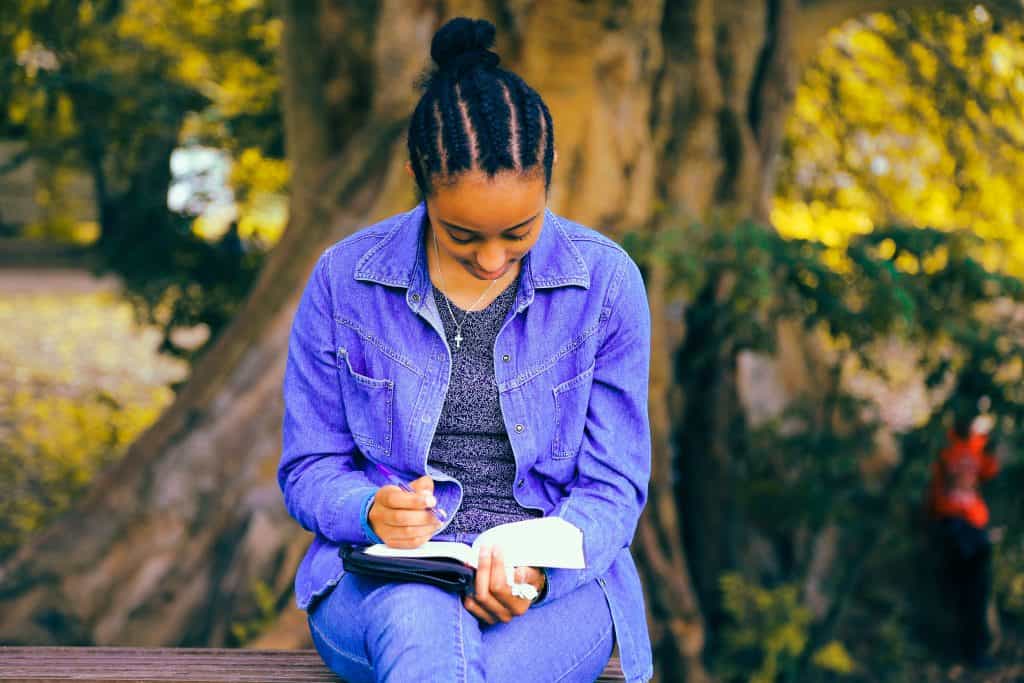 Woman writing her dad's memoir in a park