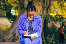 Woman writing a book in a park