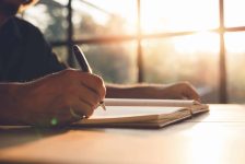 Checklist Writing Notice Remember Planning Concept,home office desk background,hand holding pen and writing note on wood table.