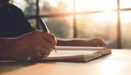 Checklist Writing Notice Remember Planning Concept,home office desk background,hand holding pen and writing note on wood table.