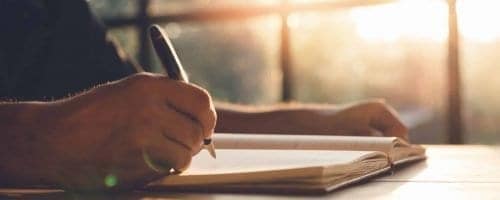 Checklist Writing Notice Remember Planning Concept,home office desk background,hand holding pen and writing note on wood table.